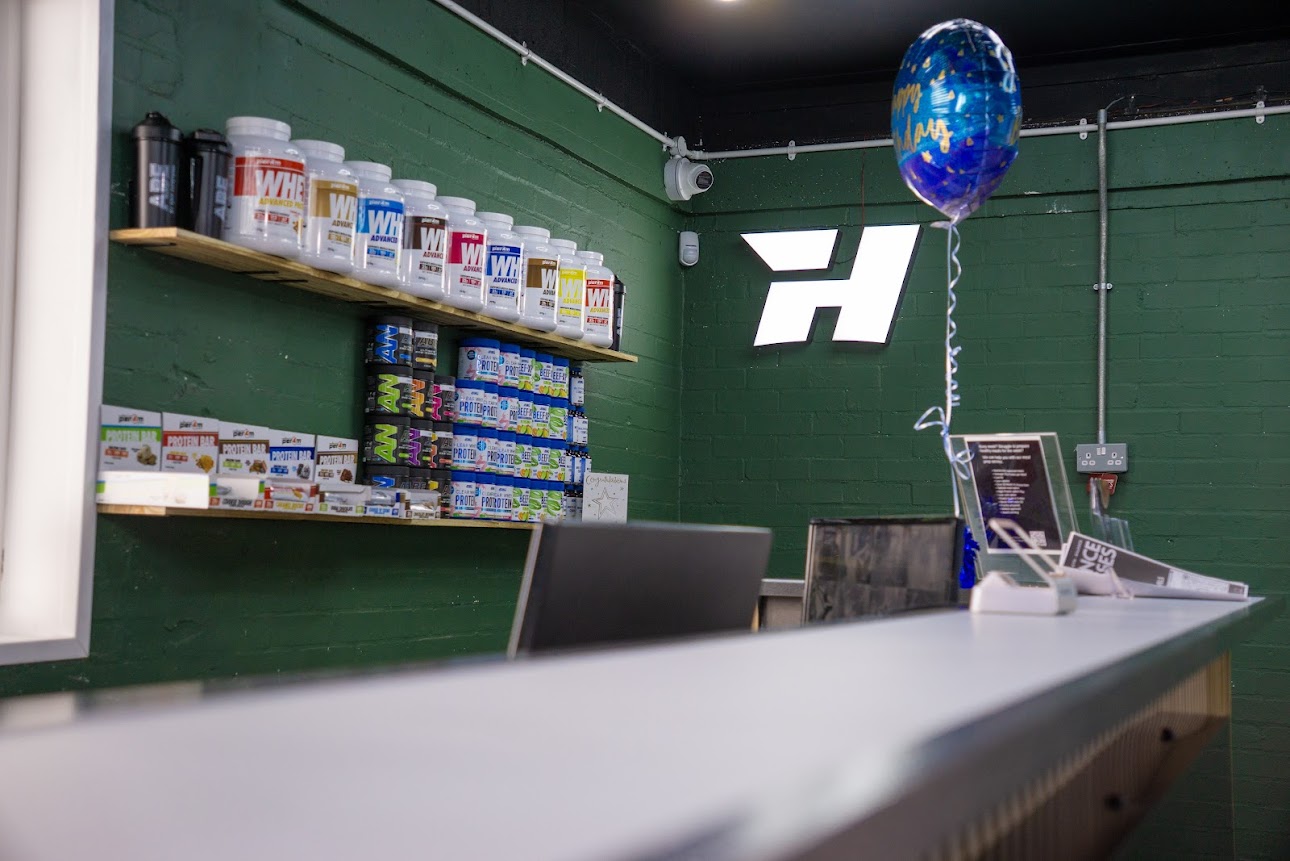 Reception and supplement bar with green wall and Hype Gym logo